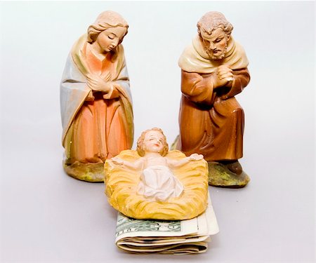 Commercialism vs Christmas, Mary and Joseph looking at baby Jesus, with money under the manger. Foto de stock - Super Valor sin royalties y Suscripción, Código: 400-04012890