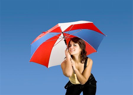 simsearch:400-03996893,k - Portrait of a young happy woman posing with an umbrella on a blue background Stock Photo - Budget Royalty-Free & Subscription, Code: 400-04013407