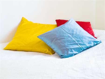 Three colorful pillows on a white bed Stockbilder - Microstock & Abonnement, Bildnummer: 400-04024275