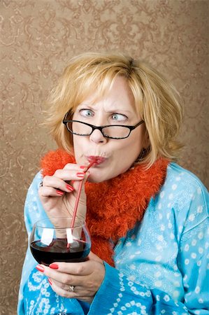 Crazy woman with crossed eyes drinking wine through a straw Foto de stock - Royalty-Free Super Valor e Assinatura, Número: 400-04024495