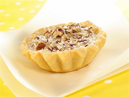 rosinen-karamell-küchlein - A single pecan tart lightly sprinkled with confectioner's sugar. Stockbilder - Microstock & Abonnement, Bildnummer: 400-04025071