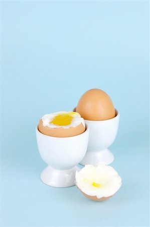 Hard boiled eggs and egg cups isolated against a blue background Stock Photo - Budget Royalty-Free & Subscription, Code: 400-04026035