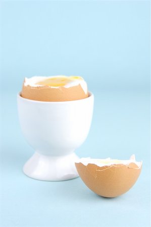 Hard boiled eggs and egg cups isolated against a blue background Stock Photo - Budget Royalty-Free & Subscription, Code: 400-04026032