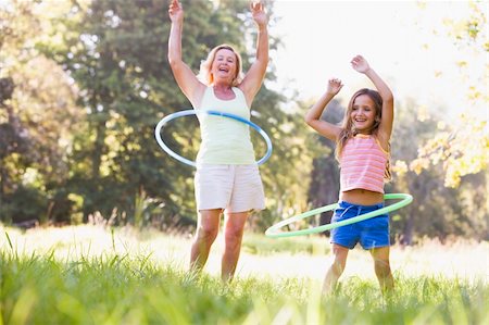 Grandmother and granddaughter at a park hula hooping and smiling Stock Photo - Budget Royalty-Free & Subscription, Code: 400-04026628