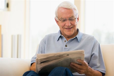 simsearch:400-05736257,k - Man in living room reading newspaper smiling Stock Photo - Budget Royalty-Free & Subscription, Code: 400-04026704
