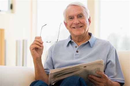 simsearch:400-04026722,k - Man in living room reading newspaper smiling Stock Photo - Budget Royalty-Free & Subscription, Code: 400-04026705