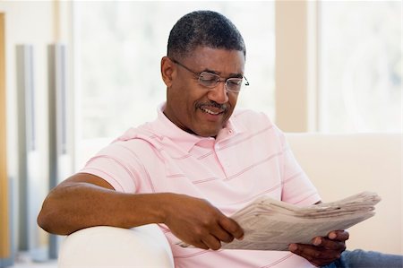 simsearch:400-05736257,k - Man relaxing with a newspaper smiling Stock Photo - Budget Royalty-Free & Subscription, Code: 400-04026700