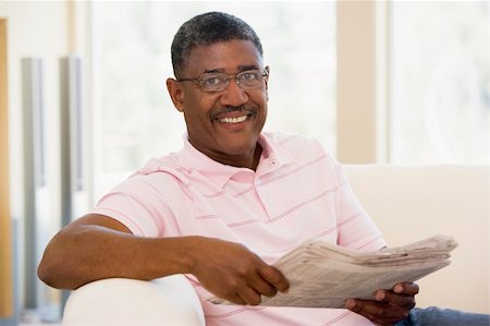 simsearch:400-05736257,k - Man relaxing with a newspaper smiling Stock Photo - Budget Royalty-Free & Subscription, Code: 400-04026701