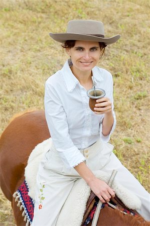 simsearch:400-04529072,k - A young Argentinean gaucha relaxing with yerba mate while riding her horse. Photographie de stock - Aubaine LD & Abonnement, Code: 400-04026985