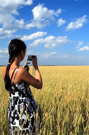 girl costs in a wheaten floor with the camera in hands Stock Photo - Budget Royalty-Free & Subscription, Code: 400-04027027