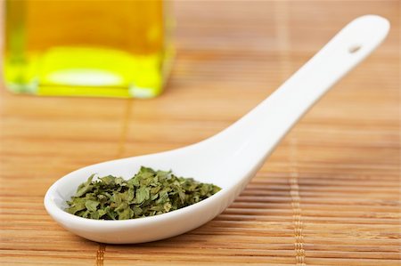 simsearch:400-04047920,k - Parsley in the spoon and oil bottle for prepare tasty food with soft shadow in the bamboo mat background. Shallow depth of field Stock Photo - Budget Royalty-Free & Subscription, Code: 400-04027192
