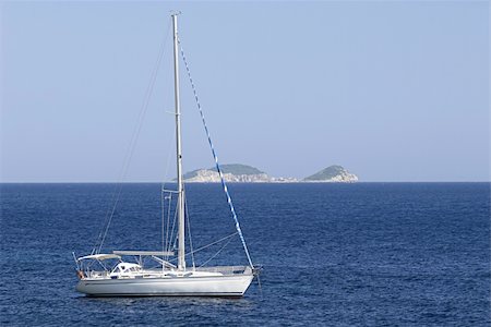 simsearch:400-07975148,k - White sail boat anchored close to an island Foto de stock - Super Valor sin royalties y Suscripción, Código: 400-04028062