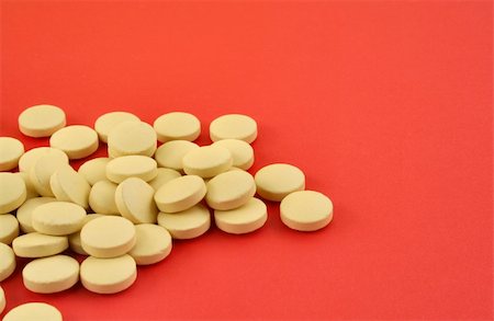 simsearch:400-07994748,k - handful of yellow tablets on red Photographie de stock - Aubaine LD & Abonnement, Code: 400-04020278
