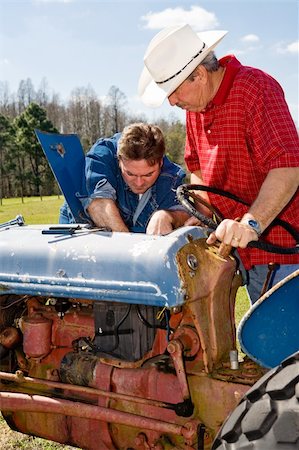 farmer with hat tractor and field - Ranch hand repairing a tractor as the rancher supervises. Stock Photo - Budget Royalty-Free & Subscription, Code: 400-04020533