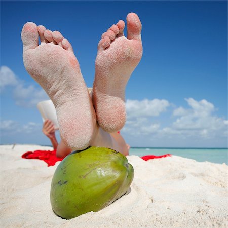 Woman reading on the beach with her feeton a green coconut. Stock Photo - Budget Royalty-Free & Subscription, Code: 400-04021373