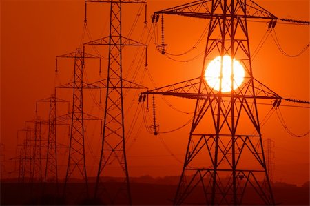 Setting Sun seen through a row of electricity pylons Stock Photo - Budget Royalty-Free & Subscription, Code: 400-04021583