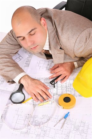 A businessman sleepy with architectural plans at desk Stock Photo - Budget Royalty-Free & Subscription, Code: 400-04021772