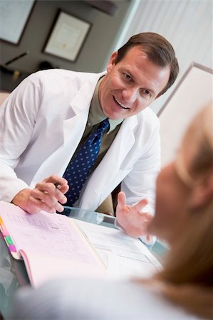 simsearch:400-04021788,k - Doctor in consultation with female patient sitting at desk Stock Photo - Budget Royalty-Free & Subscription, Code: 400-04021792