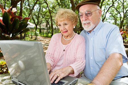simsearch:400-04065020,k - Senior couple with laptop browses the internet in a beautiful outdoor setting. Foto de stock - Royalty-Free Super Valor e Assinatura, Número: 400-04022098
