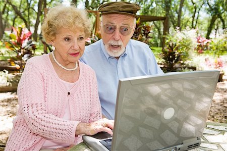 simsearch:400-04065020,k - Senior couple using their laptop computer in lovely outdoor setting.  He's shocked by what he sees online. Foto de stock - Royalty-Free Super Valor e Assinatura, Número: 400-04022103