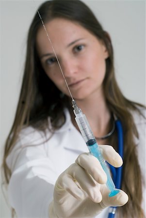 Young female doctor holding syringe in her outstretched arm. Isolated. Stock Photo - Budget Royalty-Free & Subscription, Code: 400-04022130