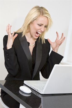 scream computer mad - A beautiful young female executive expressing frustration at her laptop computer Stock Photo - Budget Royalty-Free & Subscription, Code: 400-04023661