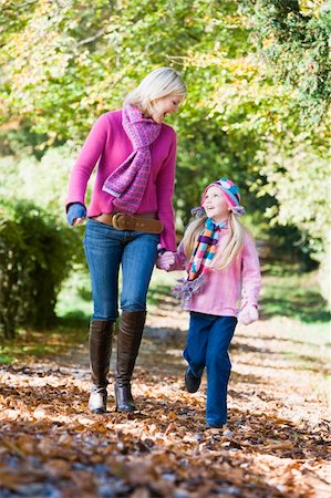 simsearch:400-05686748,k - Mother and daughter walking along autumn path through trees Fotografie stock - Microstock e Abbonamento, Codice: 400-04034999