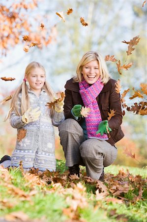 Mother and daughter throwing autumn leaves in the air Stock Photo - Budget Royalty-Free & Subscription, Code: 400-04035079