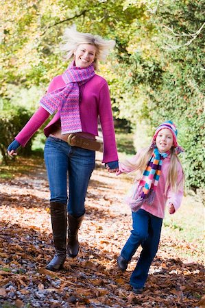 simsearch:400-05686748,k - Mother and daughter running along path through autum woods Fotografie stock - Microstock e Abbonamento, Codice: 400-04035116