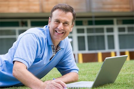 student college laptop lying grass - Man using laptop while lying in grass on campus Stock Photo - Budget Royalty-Free & Subscription, Code: 400-04035231