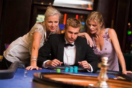 Man with glamorous women in casino at roulette table Stock Photo - Budget Royalty-Free & Subscription, Code: 400-04035676