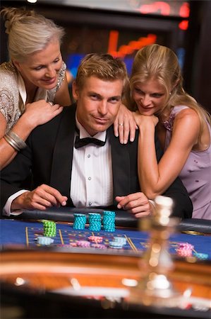 Man gambling surrounded by attractive women at roulette table Stock Photo - Budget Royalty-Free & Subscription, Code: 400-04035677