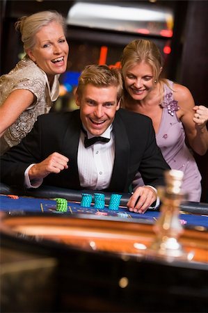 Man winning at roulette table in casino surrounded by glamorous women Stock Photo - Budget Royalty-Free & Subscription, Code: 400-04035680