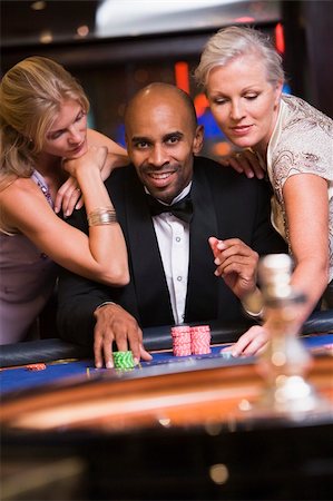 Man at roulette table in casino surrounded by glamorous women Stock Photo - Budget Royalty-Free & Subscription, Code: 400-04035713