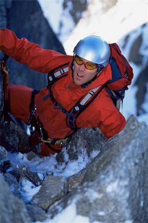 simsearch:400-04036380,k - Young man mountain climbing on snowy peak Photographie de stock - Aubaine LD & Abonnement, Code: 400-04036387