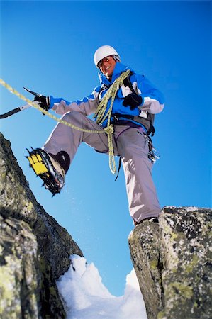 simsearch:400-04036380,k - Young man mountain climbing on snowy peak Photographie de stock - Aubaine LD & Abonnement, Code: 400-04036389