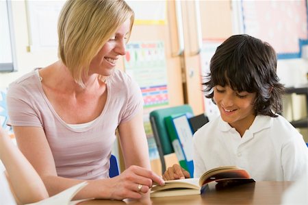 A schoolboy and his teacher reading a book in class Stock Photo - Budget Royalty-Free & Subscription, Code: 400-04036527