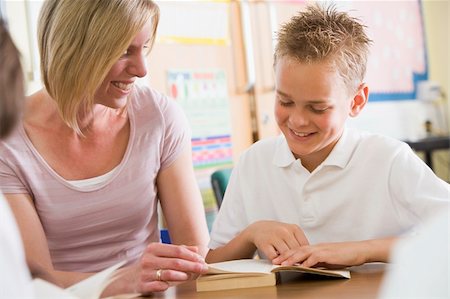 A schoolboy and his teacher reading a book in class Stock Photo - Budget Royalty-Free & Subscription, Code: 400-04036529
