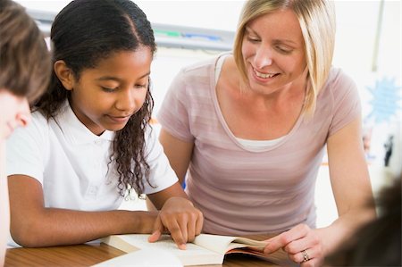 simsearch:400-04536422,k - A schoolgirl and her teacher reading a book in class Foto de stock - Super Valor sin royalties y Suscripción, Código: 400-04036530
