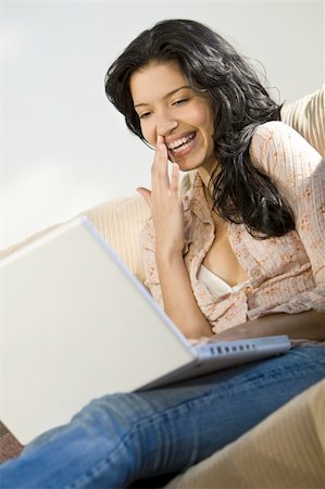 simsearch:400-04340722,k - A beautiful young Hispanic woman using her laptop and laughing Stock Photo - Budget Royalty-Free & Subscription, Code: 400-04036849