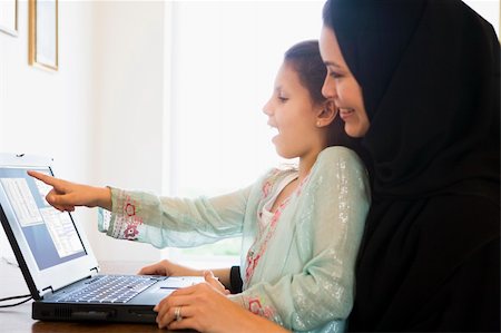 A Middle Eastern woman and her daughter sitting in front of a co Stock Photo - Budget Royalty-Free & Subscription, Code: 400-04036889