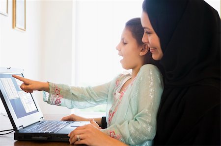 simsearch:400-04038226,k - A Middle Eastern woman and her daughter sitting in front of a co Foto de stock - Super Valor sin royalties y Suscripción, Código: 400-04036889