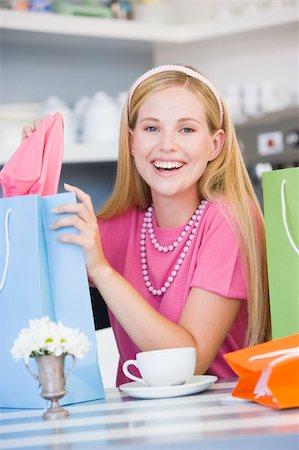 A young woman sitting in a cafe with shopping bags Stock Photo - Budget Royalty-Free & Subscription, Code: 400-04037441