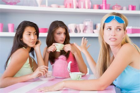 friends home upset - Two young women enjoying a tea party while one sits apart wearin Stock Photo - Budget Royalty-Free & Subscription, Code: 400-04037628