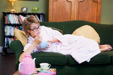 sadness and icecream - A young woman lying on her couch eating cereal Stock Photo - Budget Royalty-Free & Subscription, Code: 400-04037701