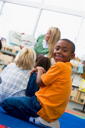 Kindergarten teacher reading to children in library, boy looking Stock Photo - Budget Royalty-Free & Subscription, Code: 400-04037804