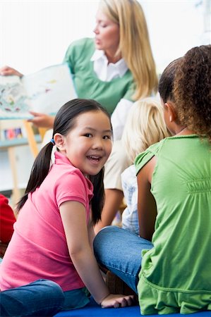 Kindergarten teacher reading to children in library, girl lookin Stock Photo - Budget Royalty-Free & Subscription, Code: 400-04037809