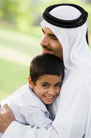 simsearch:400-04038226,k - A Middle Eastern man and his son sitting in a park Foto de stock - Super Valor sin royalties y Suscripción, Código: 400-04038212