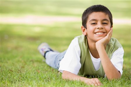 Boy relaxing in park looking to camera Foto de stock - Super Valor sin royalties y Suscripción, Código: 400-04038287