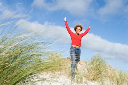 Young woman stretching amongst dunes on beach Stock Photo - Budget Royalty-Free & Subscription, Code: 400-04038813